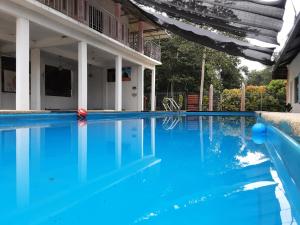 a swimming pool with blue water in front of a house at Challet Baitul Hanan with Private Pool near KLIA in Sepang