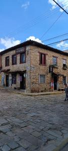um edifício de pedra numa rua de calçada em Pousada Matriz em São Thomé das Letras