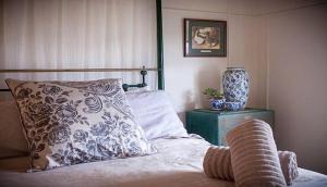 a bedroom with a bed with a pillow and a vase at Tamarind Street Cottage. Maleny, Queensland in Maleny