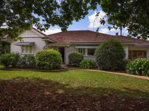 a white house with a green yard at Tamarind Street Cottage. Maleny, Queensland in Maleny