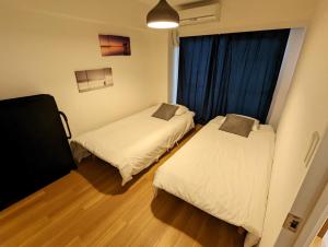 Cette petite chambre comprend 2 lits et une fenêtre. dans l'établissement Amber Iidabashi - Vacation STAY 89628v, à Tokyo