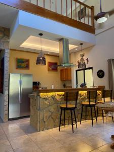 a kitchen with a refrigerator and a counter with stools at Caldera River Canyon 