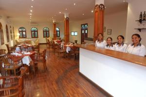 a group of women standing behind a bar in a restaurant at Sunset INN by Pro-Ema in Dili