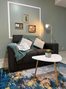 ein Wohnzimmer mit Sofa und Tisch in der Unterkunft Almas suites Cozy NETFLIX100mbps By STAY in Nusajaya