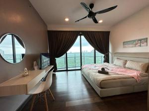 Schlafzimmer mit einem Bett, einem Schreibtisch und einem Deckenventilator in der Unterkunft Almas suites Cozy NETFLIX100mbps By STAY in Nusajaya