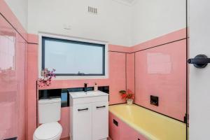 ブロークンヒルにあるMabel’s retreat 4 bedrooms,Wifi,Netflix,Kayoのピンクのバスルーム(トイレ、シンク付) +4枚の写真