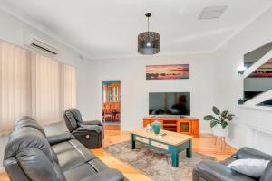 Sala de estar con sofás y mesa de centro en Mabel’s retreat 4 bedrooms,Wifi,Netflix,Kayo, en Broken Hill
