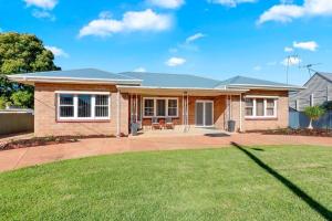 dom z trawnikiem przed nim w obiekcie Mabel’s retreat 4 bedrooms,Wifi,Netflix,Kayo w mieście Broken Hill