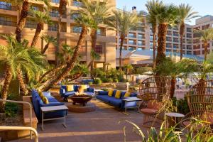 een patio van het resort met blauwe banken en palmbomen bij Renaissance Esmeralda Resort & Spa, Indian Wells in Indian Wells