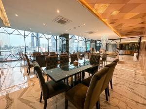S3 Siam Bangkok Hotel في بانكوك: غرفة طعام مع طاولة وكراسي زجاجية