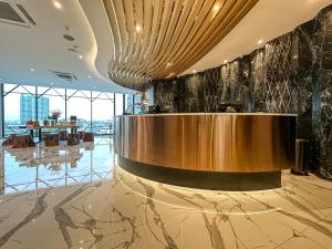 a lobby with a large gold reception desk in a building at S3 Siam Bangkok Hotel in Bangkok