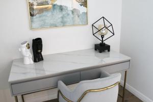 a white desk with a chair and a lamp at Kooii Apartments in Brisbane