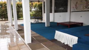 a room with a blue floor and a table and a bench at Challet Baitul Hanan with Private Pool near KLIA in Sepang