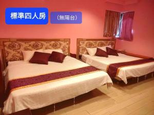 two beds in a room with a sign on the wall at Two Fish Homestay in Lanyu