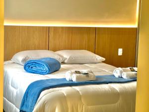 1 cama blanca grande con 3 toallas. en Rentaqui - Apartament Paulista Wall Street Diamond, en São Paulo