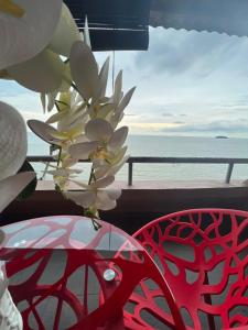 una flor en un jarrón en un balcón con el océano en PD VIP SEAVIEW w Wifi n Smart TV, en Port Dickson