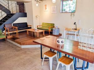 Hostel JIN - Weekly Appartment in Osaka في أوساكا: غرفة معيشة مع طاولة وكراسي