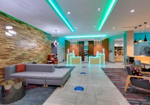 a lobby with a couch and chairs and a brick wall at La Quinta Inn & Suites by Wyndham Lakeway in Lakeway