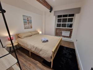 een slaapkamer met een bed in een kamer met een raam bij Delightful new period conversion in Burnley