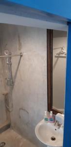 uma casa de banho com um lavatório e um chuveiro em Klai Hat Inn em Hua Hin