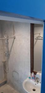 y baño con lavabo y ducha con espejo. en Klai Hat Inn, en Hua Hin