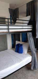 a bedroom with two bunk beds with blue pillows at Klai Hat Inn in Hua Hin