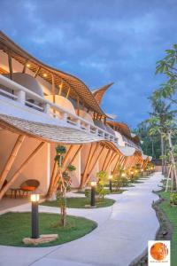 a building with a curved roof and a walkway at Pearl Sunset Resort in Gili Trawangan