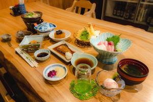 uma mesa de madeira com pratos de comida em Guest House Takiyoshi em Hongu
