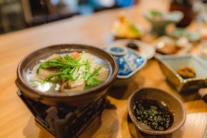a bowl of soup on a wooden table at Guest House Takiyoshi in Hongu