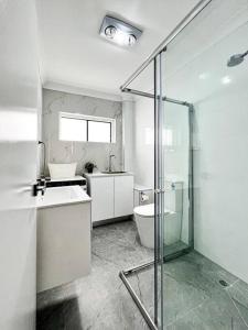 a bathroom with a shower and a sink and a toilet at Brand new 2 Bedrooms Apartment in Ingleburn in Ingleburn