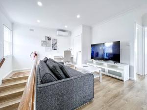 a living room with a couch and a tv at Brand new 2 Bedrooms Apartment in Ingleburn in Ingleburn