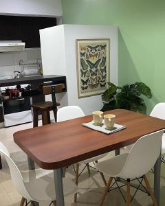 comedor con mesa de madera y sillas blancas en Moderno monoambiente, sientete como en casa! en Rosario