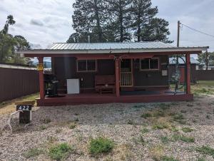 a small house with a porch and a shed at Outlaw Cache in Chama