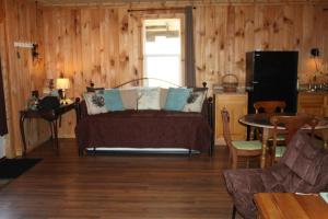 Schlafzimmer mit einem Bett, einem Tisch und einem TV in der Unterkunft Climb On Inn Naturally Gorgeous Apt #2 Red River Gorge Kentucky 