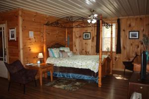 a bedroom with a bed in a room with wooden walls at Climb On Inn Naturally Gorgeous Apt #2 Red River Gorge Kentucky 