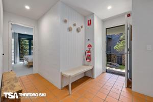 a hallway with a bench and a fire hydrant at Ironmongie 1 JackFrost in Thredbo +22 photos
