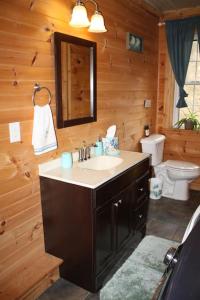 ein Bad mit einem Waschbecken und einem WC in einer Hütte in der Unterkunft Climb On Inn Naturally Gorgeous Apt #2 Red River Gorge Kentucky 