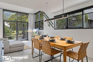 a dining room with a wooden table and chairs at Ironmongie 1 JackFrost in Thredbo