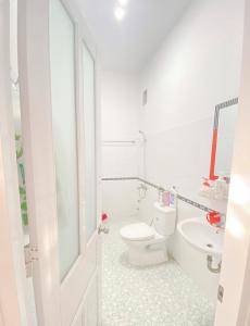 ein weißes Badezimmer mit Toilette und Waschbecken in der Unterkunft O Vững's Homestay in Vũng Tàu