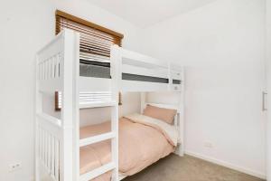 a white bunk bed in a white room with a bed at Goodie Goodwood Family Home in Unley