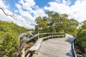 a wooden boardwalk over a river with trees at Eagles Nest Two Bed Home Nudgee Beach in Brighton