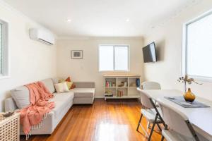 a living room with a couch and a table at Eagles Nest Two Bed Home Nudgee Beach in Brighton