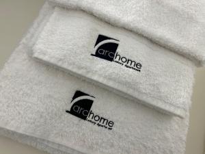 a pile of white towels with the off chrome logo on them at Archome Luxury Apartment in Brindisi