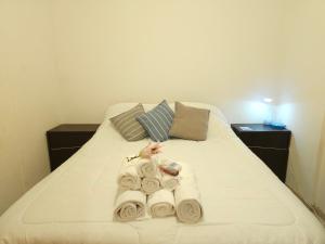 Una cama con toallas y almohadas. en Milca Celeste Nueva Córdoba en Córdoba
