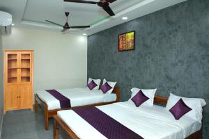 a bedroom with two beds with purple pillows at Redstone Hotel - Near US Consulate Nungambakkam in Chennai