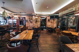 a restaurant with wooden tables and chairs and a brick wall at Urbanista Hotel & Bar in Štip
