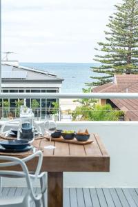 una mesa en un balcón con vistas al océano en The Sail House at Seacliff, en Seacliff