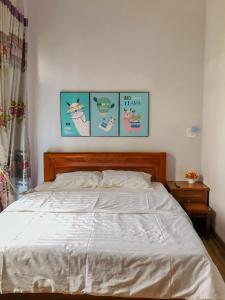 a bedroom with a bed with four pictures on the wall at Sohi Homestay in Quy Nhon