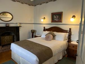 1 dormitorio con 1 cama grande y chimenea en Foundry Cottages, en Rutherglen