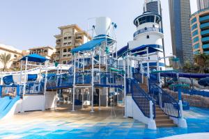 The Westin Dubai Mina Seyahi Beach Resort and Waterpark في دبي: زحليقة مائية عند المسبح على سفينة سياحية